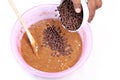 Add the choco chips to the top of the muffin batter - membuat kue muffin Royalty Free Stock Photo